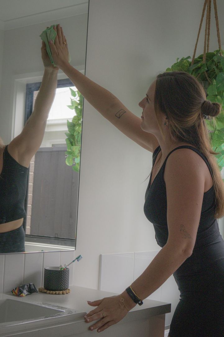 Aleka cleaning a bathroom mirror during a Super Clean