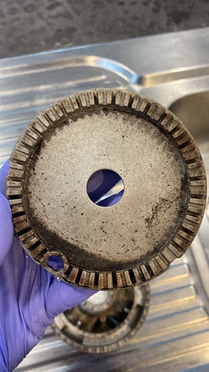 Gas burner head with baked-on grime before cleaning