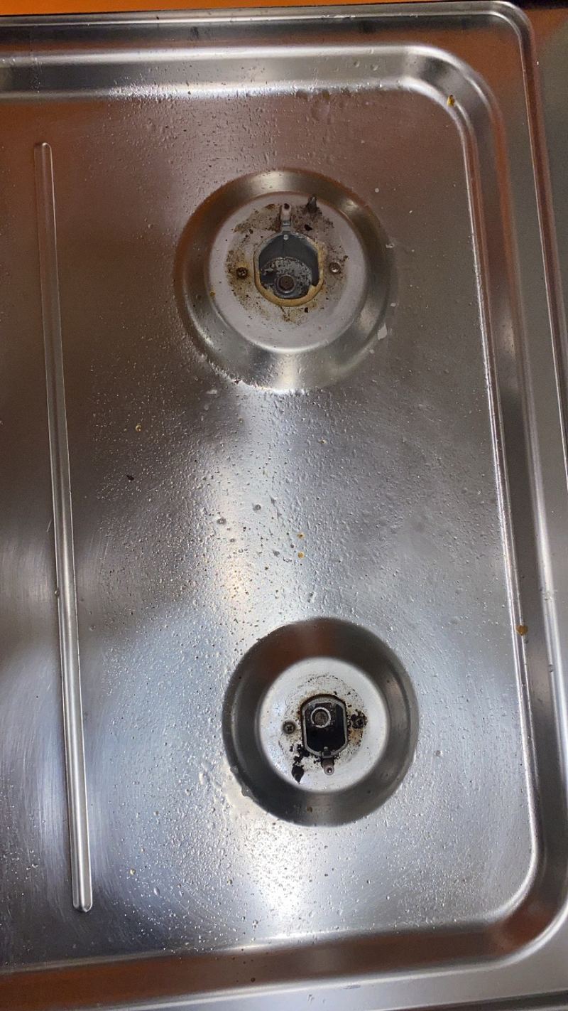 Stainless steel gas hob with grime and marks before cleaning